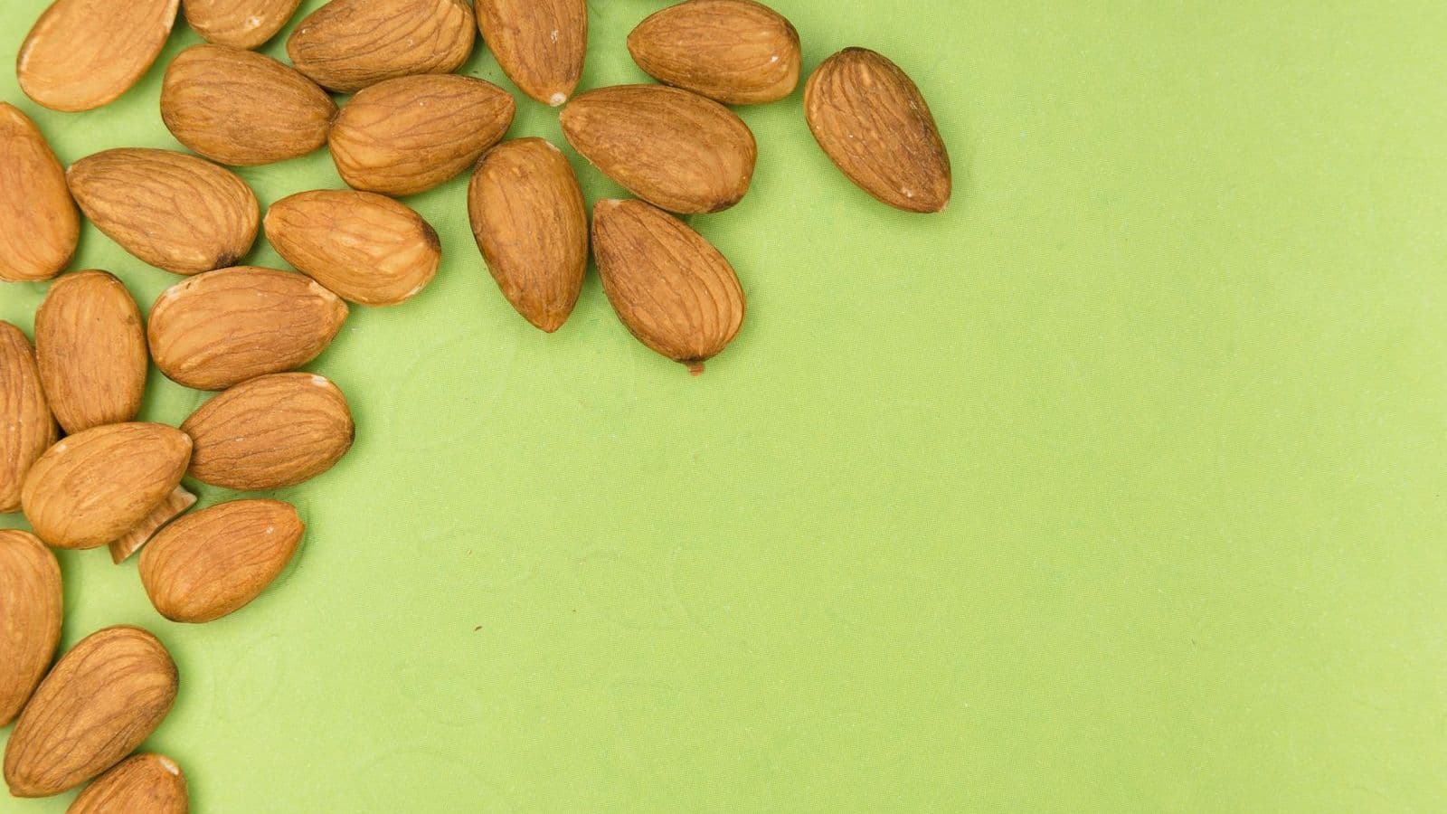 Almonds on a green background - Can Dogs Eat Almonds? Why Vets Say No