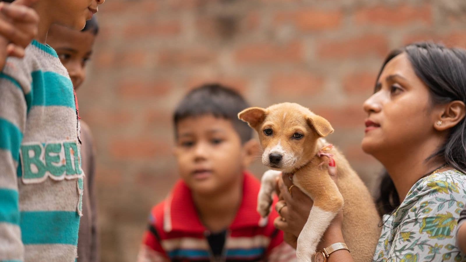 A woman and a child holding a puppy